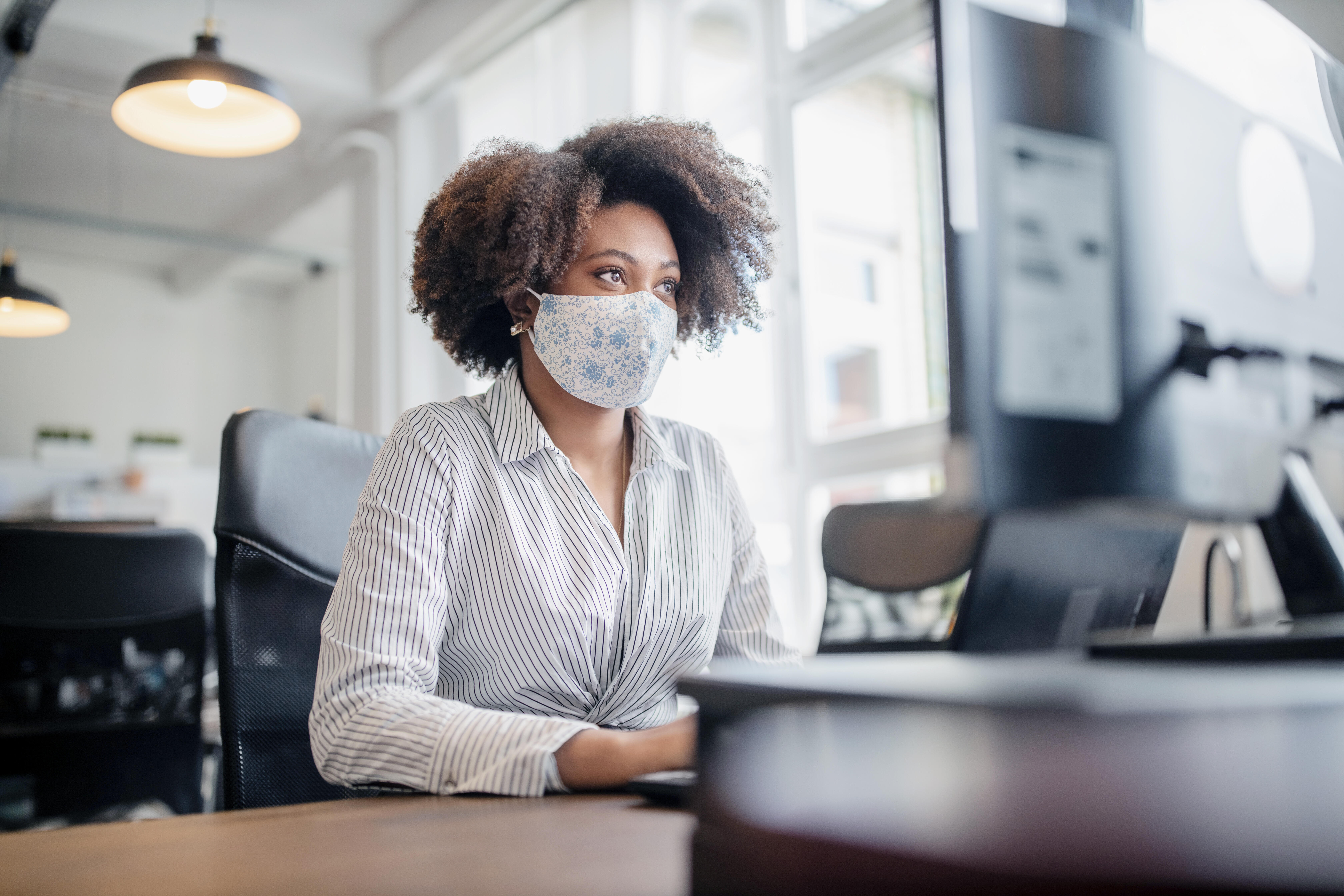 woman with mask at computer