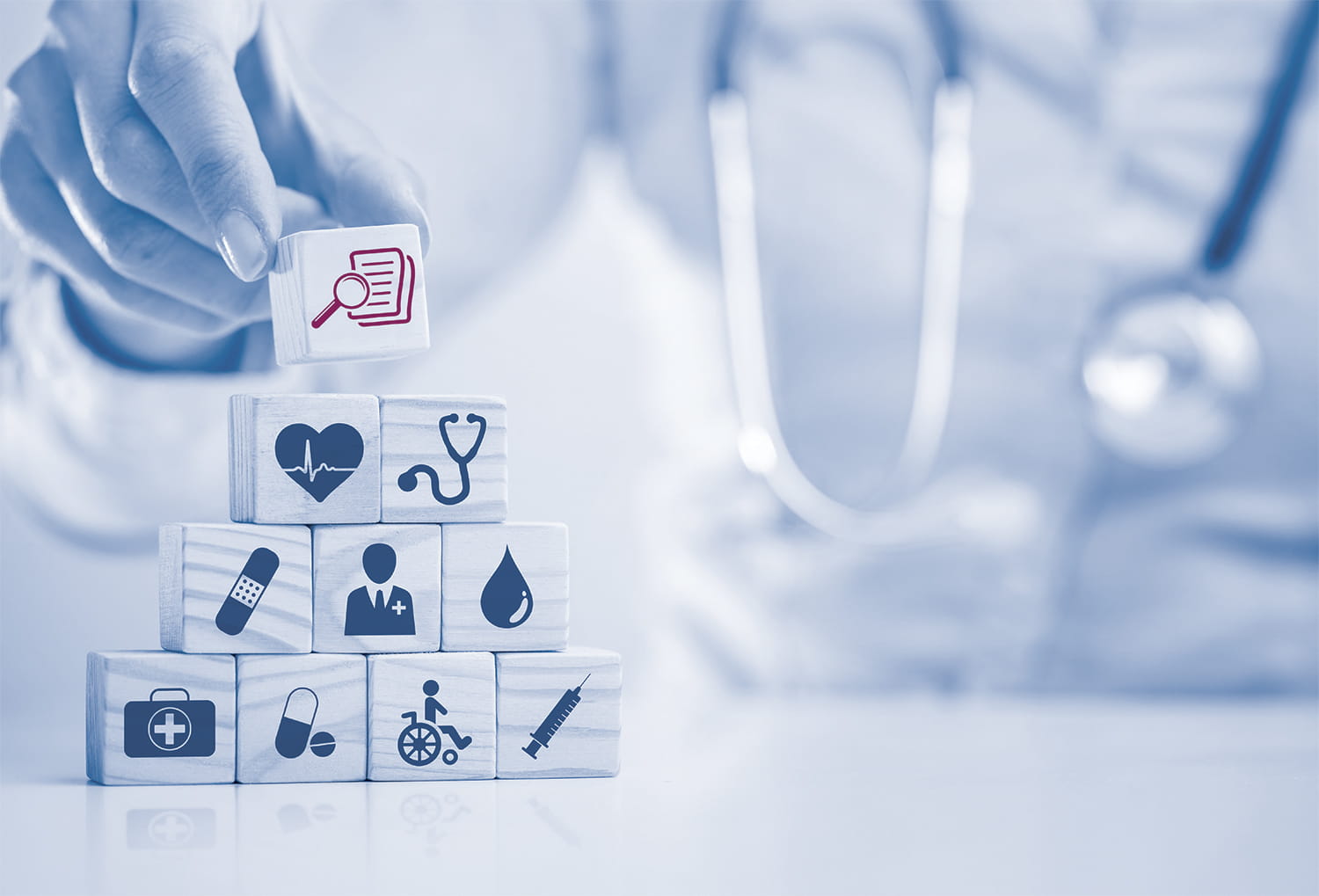 Physician's hand with healthcare blocks