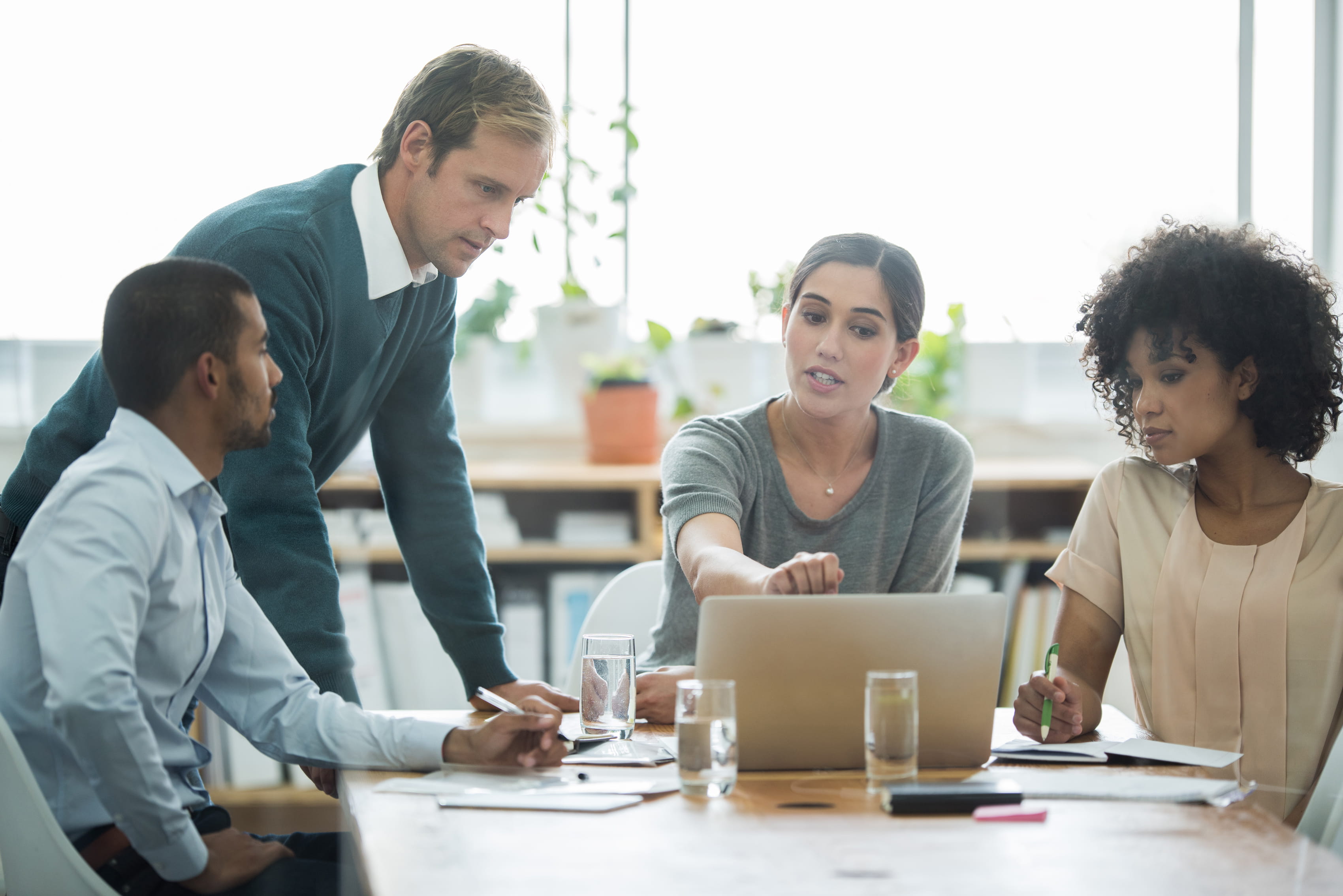 professionals discussing around computer